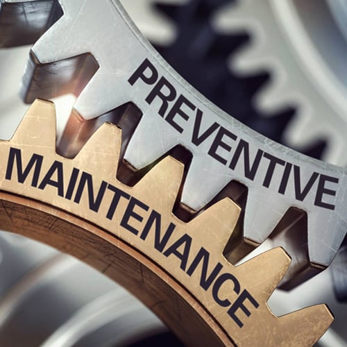 Two gears with their cogs connected, stamped with Preventive Maintenance
