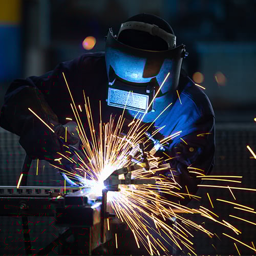 A Walters Truck and Trailer Repair service technician welding metal with sparks flying.
